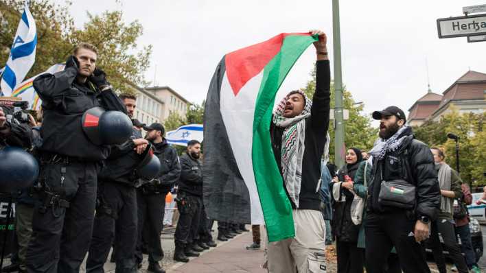 Bei einer Demo in Berlin stehen sich - getrennt von der Polizei - pro-palästinensische und pro-israelische Demonstrierende gegenüber.