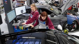 angehende KfZ-Mechatronikerinnen lesen im Volkswagen Bildungsinstitut in Zwickau den Fehlerspeicher eines vollelektrischen Porsche aus (Bild: picture alliance/dpa/Hendrik Schmidt)