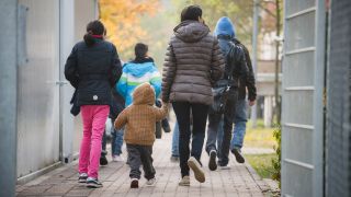 Eine Flüchtlingsfamilie geht durch die Rückführungseinrichtung für Balkanflüchtlinge in Bamberg (Archivbild).