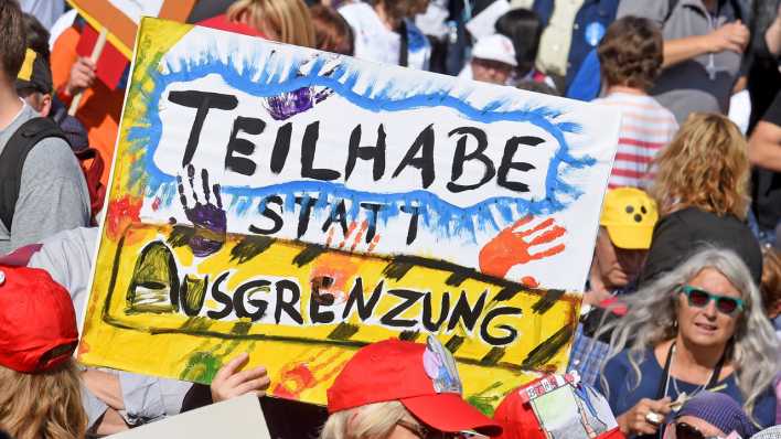 Demo mit Plakat "Teilhabe statt Ausgrenzung"