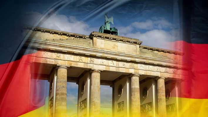 Komposition: Brandenburger Tor in Berlin auf einer Deutschland-Flagge (Bild: IMAGO / Herrmann Agenturfotografie)