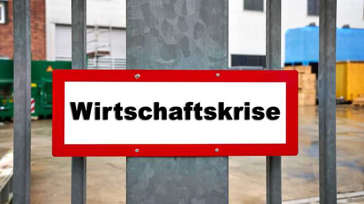 Geschlossenes Fabriktor mit Aufschrift "Wirtschaftskrise"