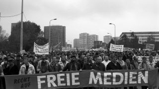 Mit einem selbst gefertigten Transparent fordern Teilnehmer der Massendemonstration am 04.November 1989 auf dem Berliner Alexanderplatz freie Medien.