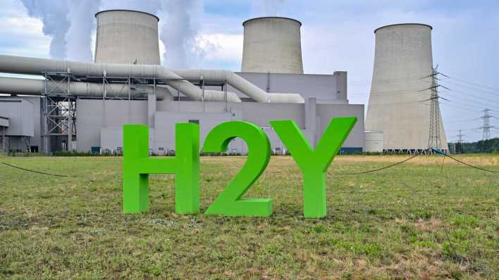 Symbolbild: chemische Element H2 (Wasserstoff) und Buchstabe Y für Hydrogen stehen vom den dampfenden Kühltürmen vom Braunkohlekraftwerk Jänschwalde der Lausitz Energie Kraftwerke AG (LEAG) (Bild: picture alliance/dpa/Patrick Pleul)