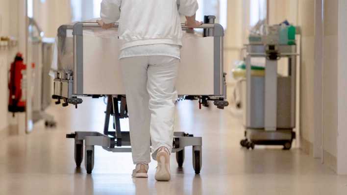 Pflegekraft schiebt Krankenbett über Krankenhausflur (Bild: picture alliance/dpa/Marijan Murat)