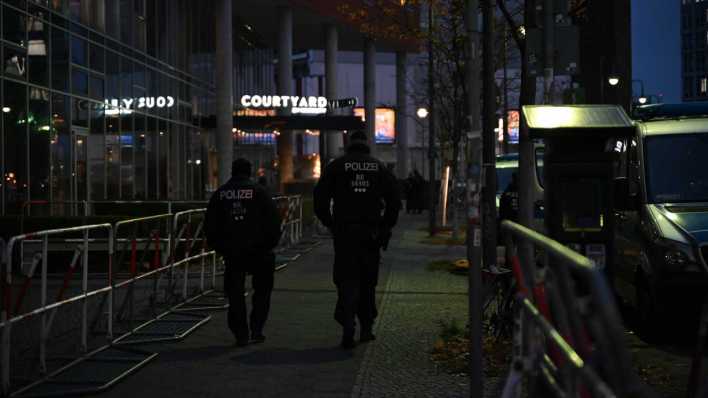 Vor dem Hotel "Courtyard by Marriott" in Berlin-Mitte laufen Polizisten an Polizeiabsperrungen entlang (Bild: picture alliance/dpa/Leonie Asendorpf)