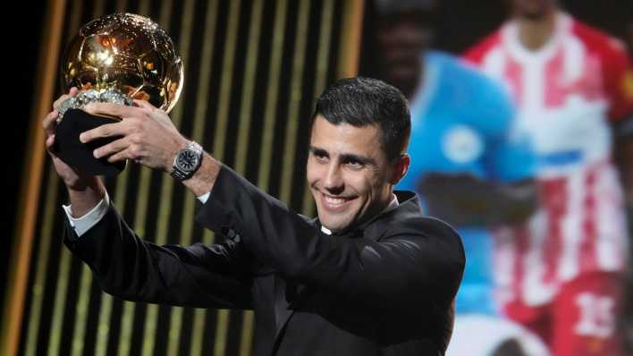 Rodri hält die Trophäe hoch bei der Preisverleihung des Ballon d'Or.