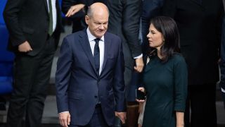 Bundeskanzler Olaf Scholz (SPD, l), und Annalena Baerbock (Bündnis 90/Die Grünen), Außenministerin, sprechen vor der Vereidigung des neuen Finanzministers Kukies im Bundestag miteinander.