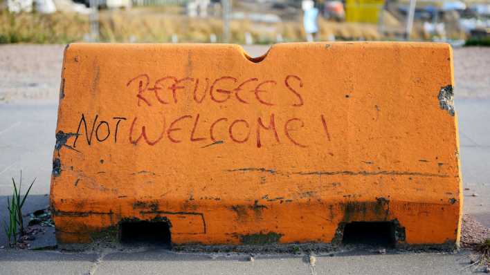 Auf einer Wegabsperrung in Hamburg steht "Refugees not welcome!" (Übersetzt: Geflüchtete nicht willkommen) (Bild: picture alliance / Bildagentur-online/Ohde)