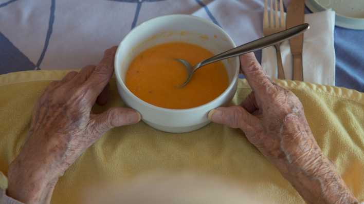 Bewohnerin einer Seniorenwohnanlage isst Suppe