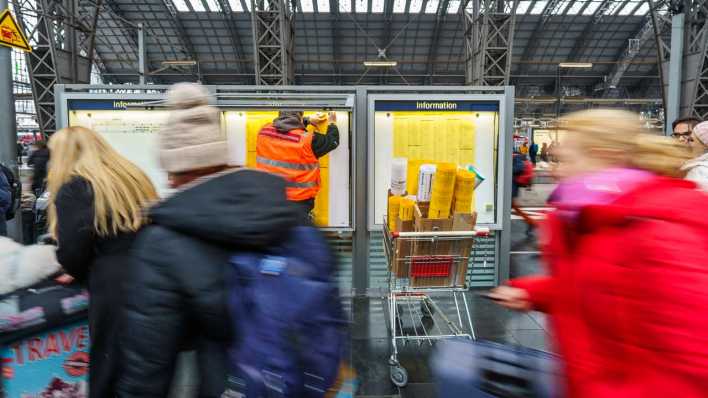 ARCHIV, 9.12.2023: in Mitarbeiter vom Bahnhofsmanagement hängt die neuen Fahrpläne in die Infokästen am Hauptbahnhof (Bild: picture alliance/dpa/Andreas Arnold)