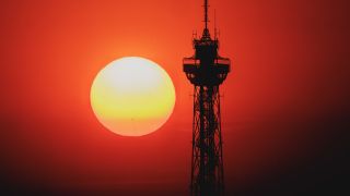 Der Sonnenaufgang zeichnet sich ab hinter dem Funkturm in Berlin.