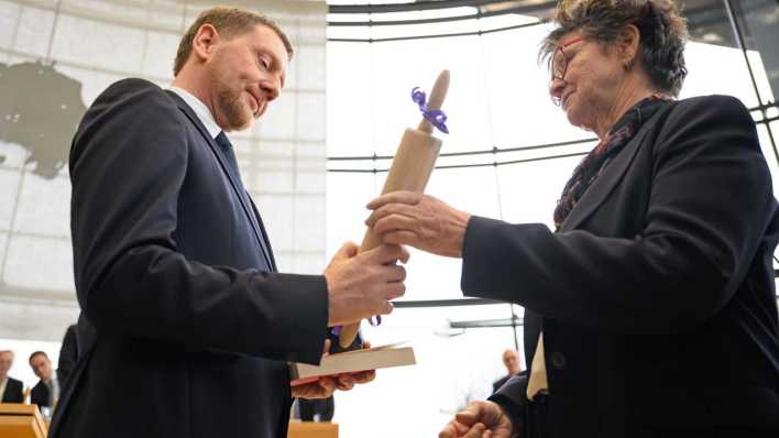 Michael Kretschmer (CDU, l) nimmt nach der Wahl zum Ministerpräsidenten von Sachsen im Plenarsaal im Sächsischen Landtag Glückwünsche von Sabine Zimmermann, Co-Vorsitzende des BSW Sachsen, entgegen (Bild: picture alliance/dpa/Robert Michael)