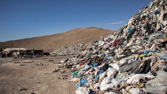 Gebrauchte Kleidungsstücke liegen in einer Müll-Deponie in der Wüste (Bild: picture alliance/dpa/Antonio Cossio)