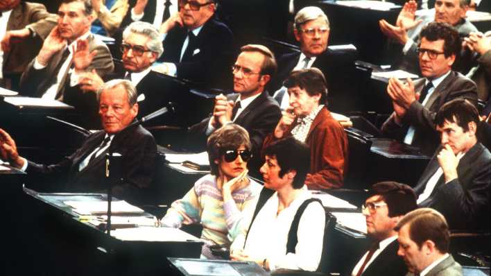 Marieluise Beck und Petra Kelly sitzen am 04.05.1983 neben weiteren Mitgliedern des Bundestags im Plenarsaal.