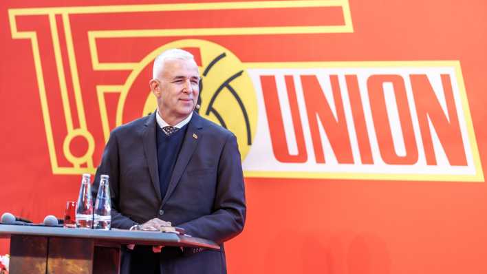 Dirk Zingler, Präsident des 1.FC Union Berlin steht auf der Bühne. (Bild. picture alliance/dpa/Andreas Gora)