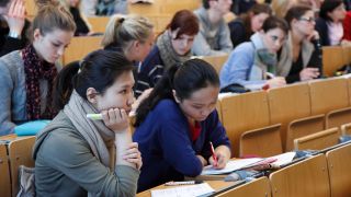 Studierende sitzen in einer Vorlesung in einem Hörsaal der FU Berlin.