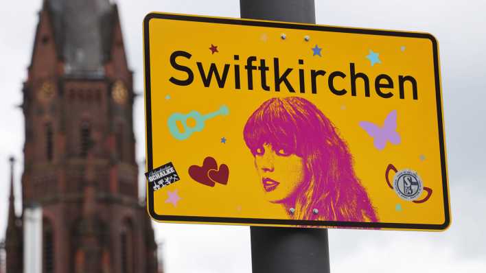 Ein Ortsschild mit der Aufschrift Swiftkirchen statt Gelsenkirchen und einem Konterfei der Sängerin Taylor Swift.