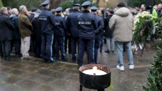 Trauernde stehen nach einer Kranzniederlegung nach dem tödlichen Angriff in einem Park in Aschaffenburg.