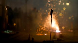 Eine Rakete und Funken sprühendes Feuerwerk an Silvester in Köln.