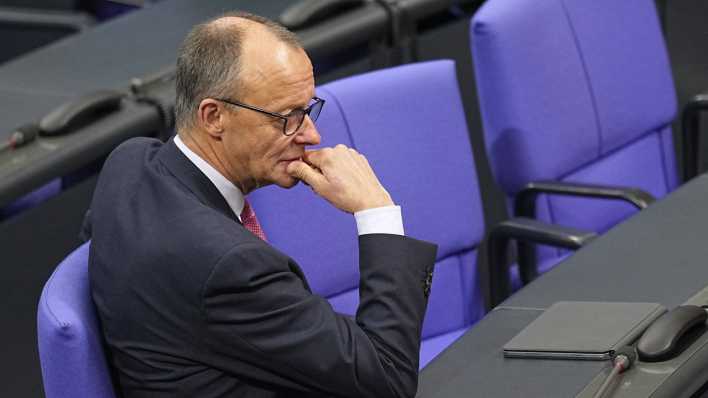 Friedrich Merz sitzt im Plenarsaal im Bundestag.