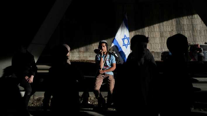 Israelische Demonstranten blockieren eine Straße, um gegen die ausgehandelte Waffenruhe zwischen Israel und der Hamas zu protestieren.