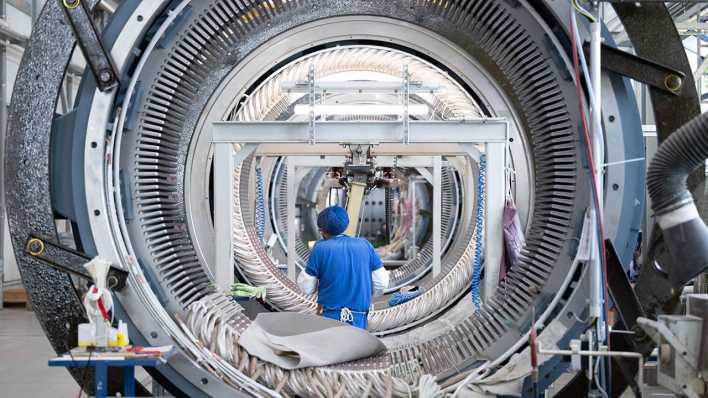 Ein Mitarbeiter der Partzsch Unternehmensgruppe im sächsischen Döbeln arbeitet in einer Fertigungshalle an einem Stator für Windkraftanlagen.