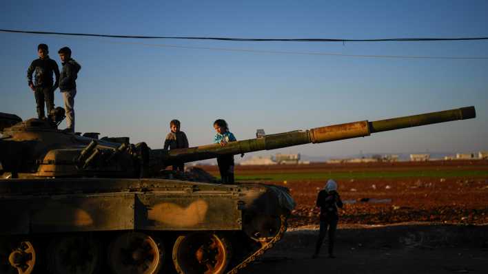 Kinder stehen auf einem Panzer der syrischen Regierungstruppen, der auf einer Straße in der Stadt Marea am Rande der Stadt Aleppo zurückgelassen wurde.