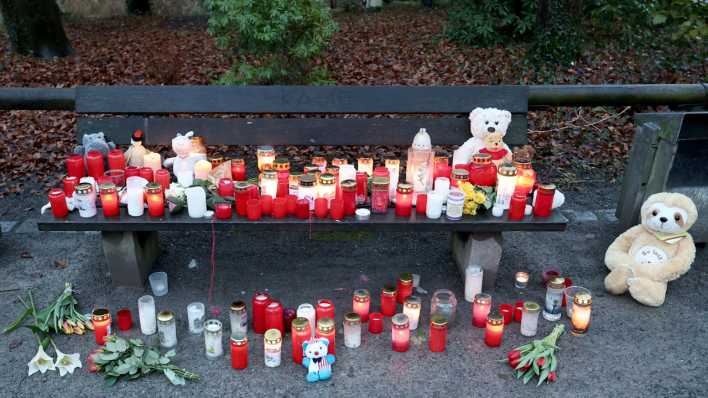 Trauerkerzen, Blumen und Kuscheltiere liegen nach dem tödlichen Angriff in einem Aschaffenburger Park am Tatort auf einer Bank