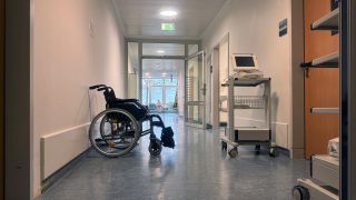 Ein Rollstuhl steht in einem Flur eines Krankenhauses