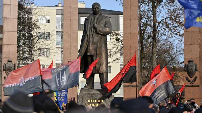 Vor einer Statue in Lwiw erinnern Menschen dem Geburtstag des ukrainischen Nationalisten Stepan Bandera.