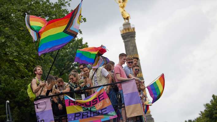 Menschen feiern auf einem Wagen beim 46. Berlin Pride Umzug zum Christopher Street Day (CSD) in Sichtweite der Siegessäule.