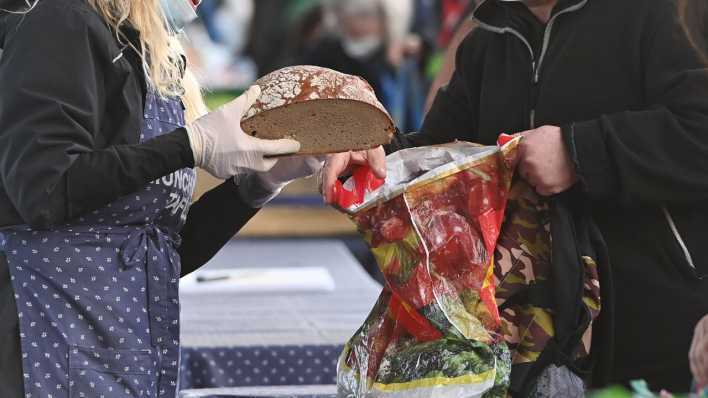 Bei der Tafel reicht eine Helferin Brot.