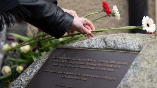 Zwei Frauen legen während einer Gedenkveranstaltung am 19. Todestag der Berlinerin Hatun Aynur Sürücü Blumen auf ihrem Gedenkstein ab (Bild: picture alliance/dpa/Sebastian Christoph Gollnow)