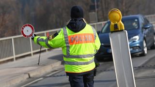 Eine Grenzpolizistin stoppt ein Fahrzeug an der deutsch-österreichischen Grenze.