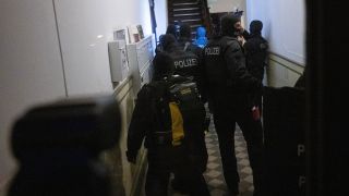 Polizisten gehen bei einem Einsatz in eine Wohnung in Berlin.