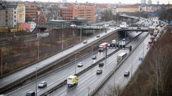 Autos fahren auf der Stadtautobahn A100 neben der Ringbahnstation Westend.