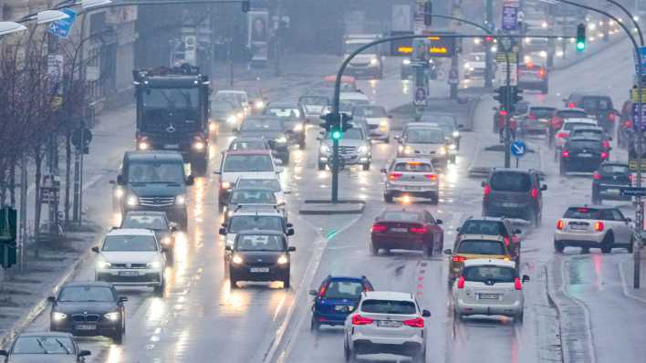 Die Lichter der Scheinwerfer der auf der Breiten Straße in der Potsdamer Innenstadt fahrenden Autos und LKW werden am Morgen von der regennassen Straße reflektiert. (Bild: picture alliance/dpa /Sören Stache)