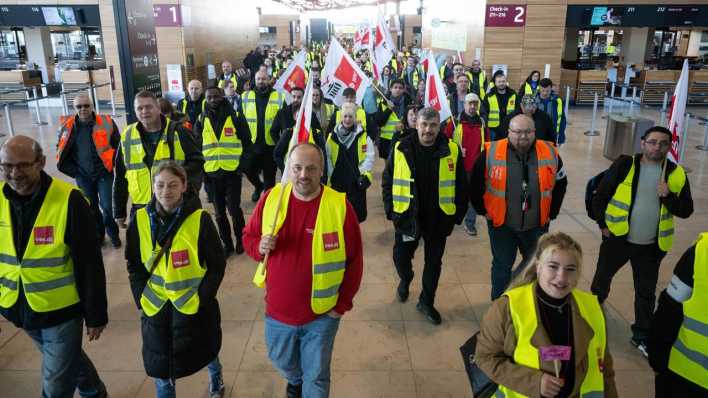 Streikende Flughafenbeschäftigte gehen durch das Terminal am Flughafen Berlin Brandenburg BER