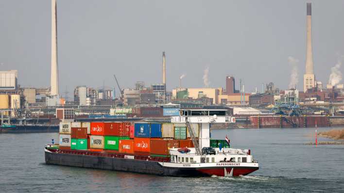 Frachtschiff fährt auf dem Rhein vorbei am Chemiewerk Chempark (Bild: imago images/Rupert Oberhäuser)