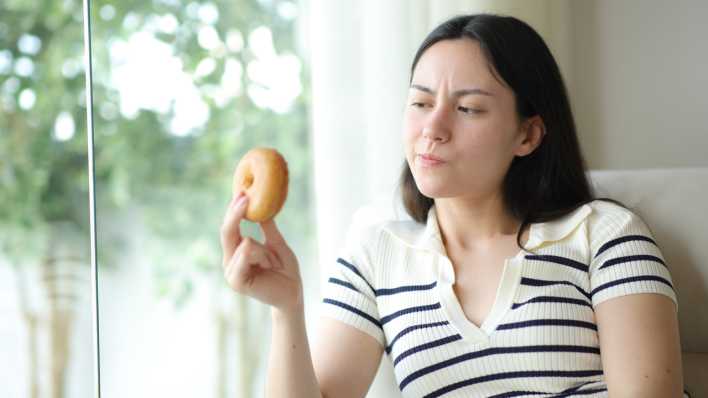 Frau mit Donut in der Hand