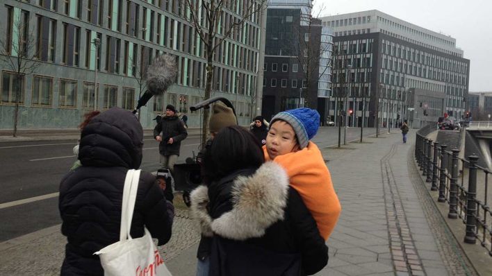 Der sechsjährige Ai Lao auf dem Arm seiner Mutter, eingepackt in eine wärmende Decke. - Foto: rbb Inforadio/Nadine Kreuzahler